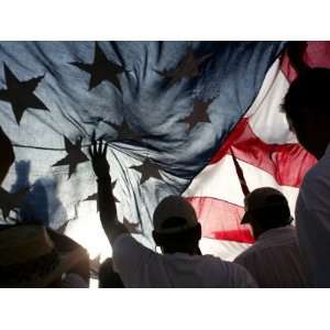 Immigration Rights Demonstrators Hold a U.S. Flag Aloft During a March 