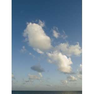 White Puffy Clouds with Blue Sky Growing from Horizon above the Ocean 